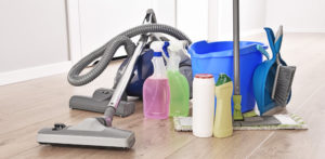 Vacuum cleaner and variety of detergent bottles and chemical cleaning supplies on the floor